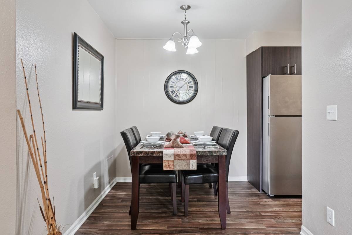 Dining area next to a stainless refrigerator, from Unit 327's renovated listing